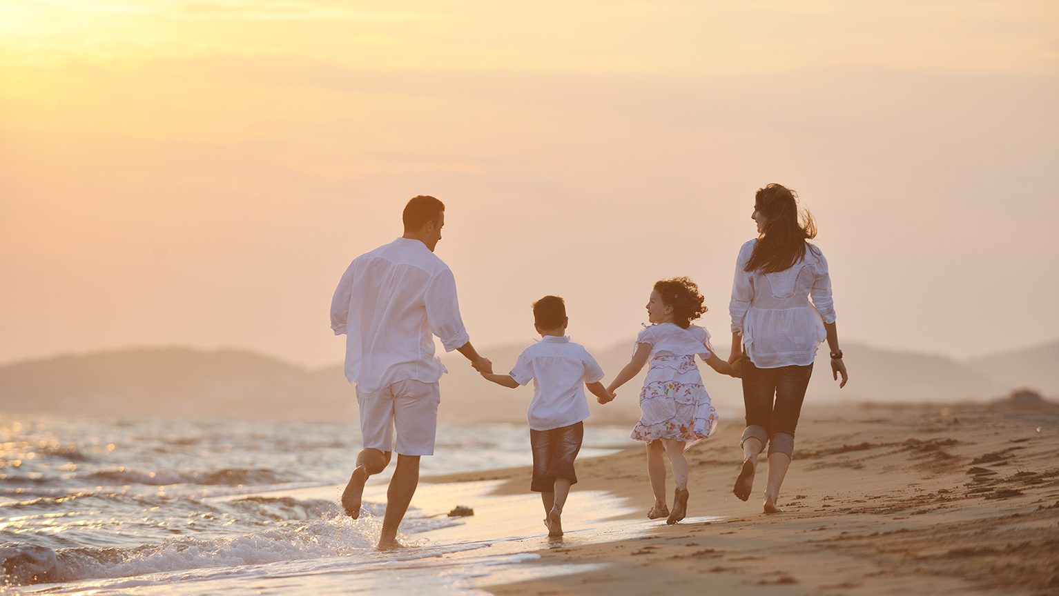 海辺を歩く家族