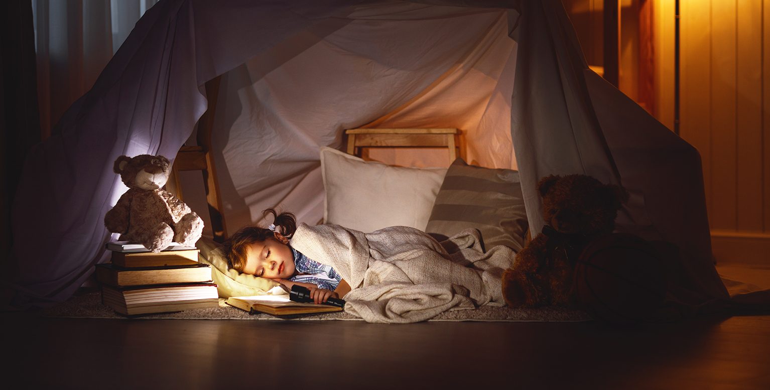 本を読みながら眠る子